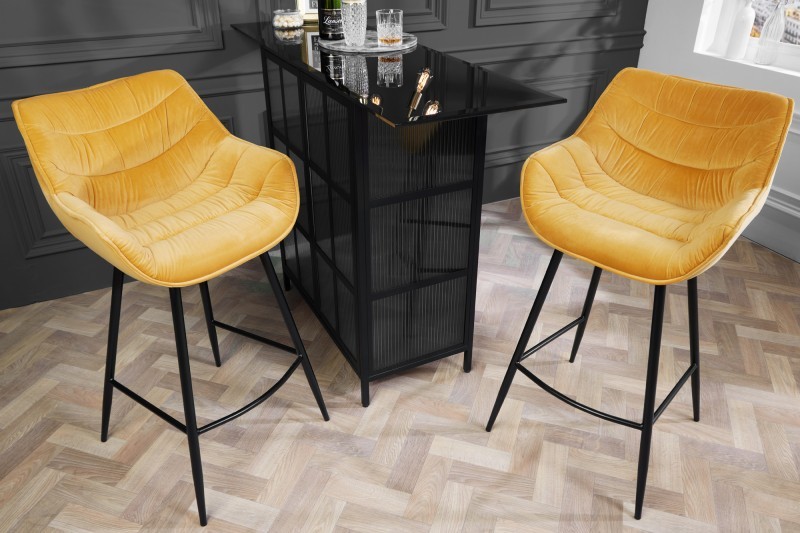 Levně Estila Industriální designová barová židle Kotor ve žlutém provedení se sametovým potahem a černou kovovou konstrukcí 105cm
