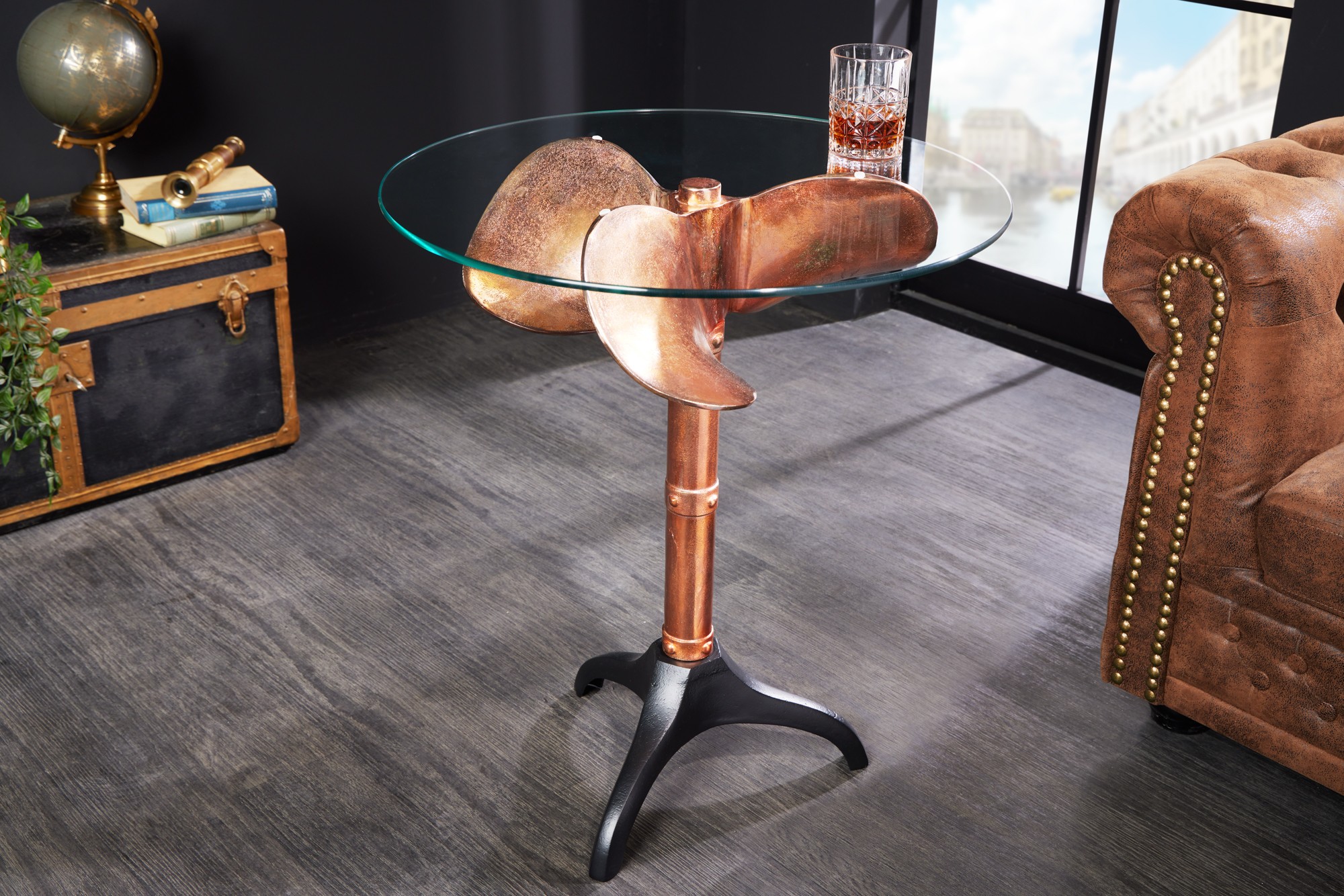 Estila Koloniální kulatý příruční stolek Helice s nohou v měděné barvě s designem lodního šroubu a skleněnou vrchní deskou 73 cm