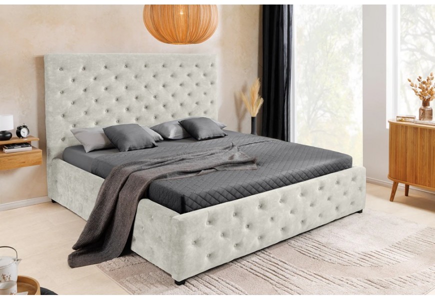 Moderní chesterfield manželská postel Kreon s čalouněním s prošíváním s kulatými knoflíčky s potahem ze sametu v šampaňské béžové barvě s vysokým obdélníkovým čelem na nízkých černých nožičkách s úložným prostorem