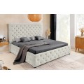 Moderní chesterfield manželská postel Kreon s čalouněním s prošíváním s kulatými knoflíčky s potahem ze sametu v šampaňské béžové barvě s vysokým obdélníkovým čelem na nízkých černých nožičkách s úložným prostorem