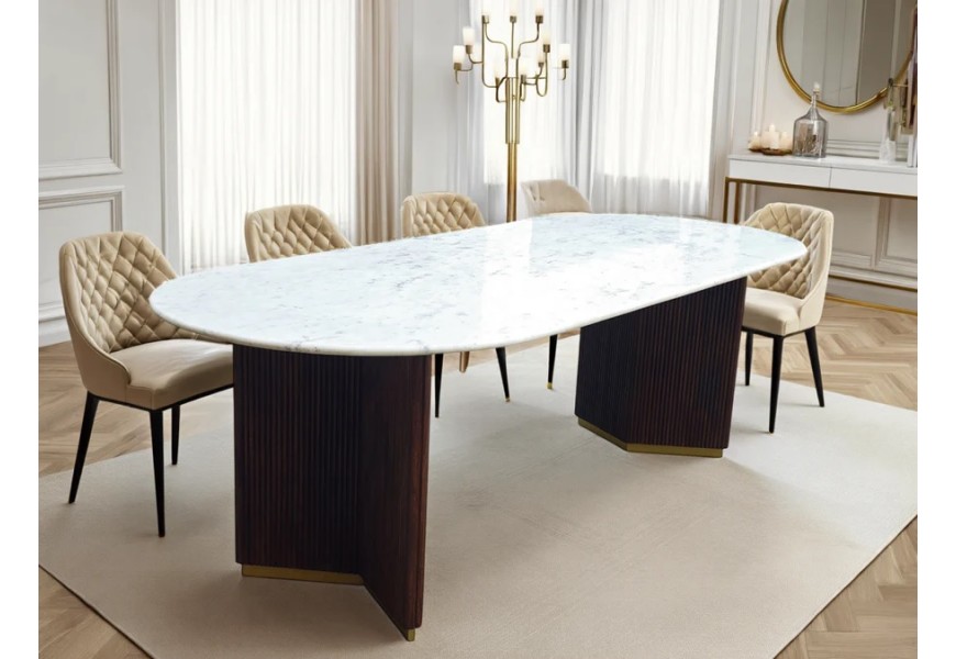 Luxusní mramorový jídelní stůl Gatsby s bílou oválnou vrchní deskou s šedým žilkováním a dvěma masivními mangovými nohama v tmavě hnědé barvě s vertikálním drážkovaným reliéfem se zlatým detailem s půdorysem ve tvaru V