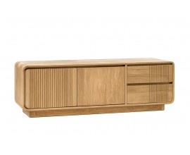 Luxusní masivní televizní stolek Riga z teakového dřeva ve světle hnědé farbě obdélníkového tvaru se zaoblenými hranami s waterfall designem s lineárním vyřezávaným reliéfním zdobením s dvoudveřovou skříňkou a dvěma šuplíky