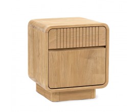 Luxusní moderní noční stolek Riga s úložným prostorem s jednodveřovou skříňkou a zásuvkou zdobenou vertikálním lineárním reliéfem se zaoblenými rohy a úzkou plnou podstavou z masivního teakového dřeva ve světle hnědé barvě s naturální kresbou letokruhů