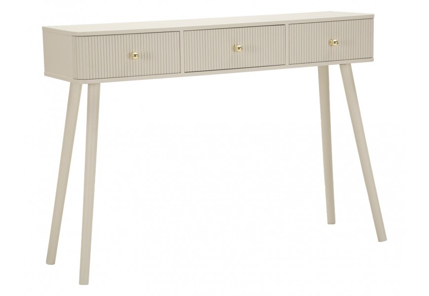 Art deco béžový konzolový stolek Shelly s obdélníkovou vrchní deskou se zaoblenými předními rohy se třemi zásuvkami s kulatými zlatými úchyty s drážkovaným reliéfem na přední a zadní straně na šikmých nožičkách