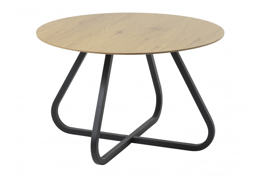 Moderní industriální jídelní stůl Holstebro s kulatou vrchní deskou z melaminové dýhy v přírodním světlém hnědém dubovém provedení a podstavou z kovu v černé barvě se čtyřmi zakřivenýma nohama a spojnicí ve tvaru kříže