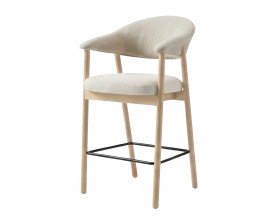 Modern&iacute; barov&aacute; židle Bodil s dřevěnou světlou hnědou konstrukc&iacute; z bělen&eacute;ho dubov&eacute;ho dřeva se &scaron;ikm&yacute;ma nohama s čalouněnou z&aacute;dovou opěrkou ve tvaru U a sedadlem s kr&eacute;mově b&iacute;l&yacute;m potahem z žinylkov&eacute;ho mikrovl&aacute;kna