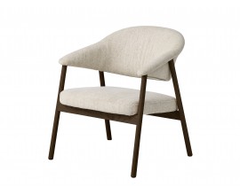 Skandin&aacute;vsk&eacute; čalouněn&eacute; křeslo Bodil s potahem z mikrovl&aacute;kna s žinylkov&yacute;m fini&scaron;em v mel&iacute;rovan&eacute;m b&iacute;lo b&eacute;žov&eacute;m proveden&iacute; s dřevěn&yacute;m r&aacute;mem se &scaron;ikm&yacute;ma nohama v dubov&eacute; tmav&eacute; hněd&eacute; barvě s přiznanou kresbou letokruhů