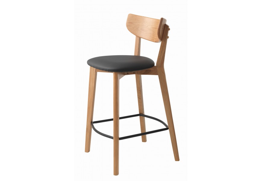 Moderní masivní barová židle Vitro konstrukcí z dubového dřeva se zaoblenou opěrkou ve světle hnědé barvě s přírodní kresbou letokruhů s čalouněným sedátkem s potahem z ekokůže v černé barvě s kovovou opěrkou na nohy