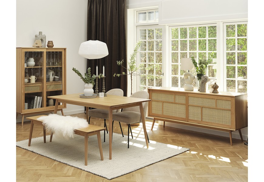 Skandinávská retro sestava nábytku do jídelny Aarhus ve světle hnědé barvě dubového dřeva s béžovým ratanovým výpletem s obdélníkovým rozkládacím stolem s lavicí a béžovými čalouněnými židlemi s barovou skříňkou s proskelnými dvířky a příborníkem