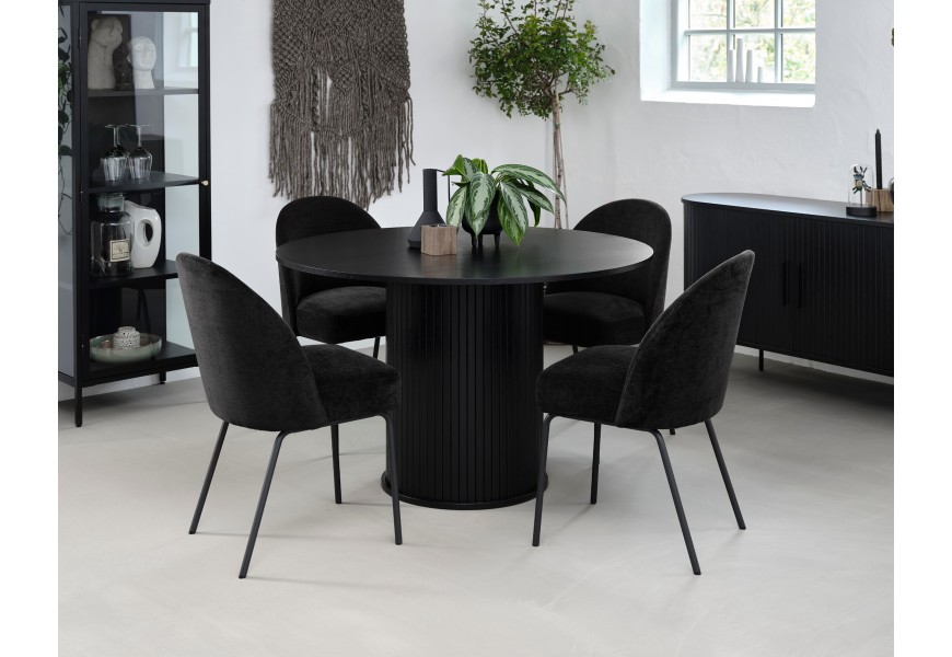 Moderní industriální černá jídelní sestava Bornholm s kulatým stolem a oválným příborníkem v dubovém dekoru s vertikálním lamelovým reliéfem s čalouněnými židlemi s žinylkovým potahem as nízkou kovovou vitrínou se čtyřmi policemi