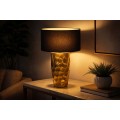 Modern&iacute; art-deco stoln&iacute; lampa Almina se zlat&yacute;m kovov&yacute;m podstavcem s klad&iacute;vkov&yacute;m efektem a čern&yacute;m textiln&iacute;m st&iacute;n&iacute;tkem 53 cm