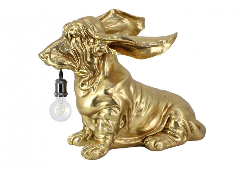 Stylová art deco stolní lampa Pop Atelier v atypickém tvaru psa jezevčíka ve zlaté barvě s dlouhýma ušima s prodlouženým tělem s krátkýma nohama s objímkou ​​v tlamě a dlouhým přívodním kabelem