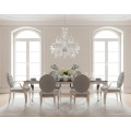Moderní klasická glamour sestava nábytku do jídelny Modern Barock se stolem a židlemi s chromovými kabriolovými nohami s obdélníkovou vrchní deskou z černého opálového skla a potahem ze sametu ve světlé šedé barvě s křišťálovým lustrem