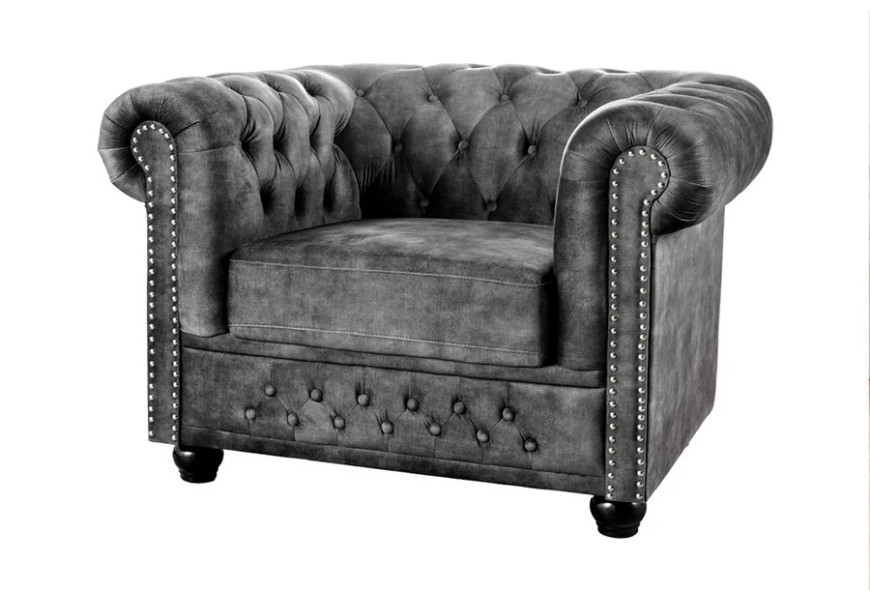 Designové klasické vintage sametové křeslo Chesterfield v šedé barvě s typickým diamantovým prošíváním s kulatými knoflíky s vyhnutou opěrkou s dekorativními vybíjenými nýty ve stříbrné barvě s vyřezávanými kulatými dřevěnými nožičkami