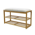 Moderní designová obdélníková lavice Bobby s čalouněným sedadlem s potahem ze strukturované látky v béžové barvě s konstrukcí z bambusu ve světle hnědé barvě se dvěma policemi na boty s lamelovou výplní