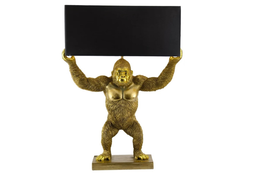Designová art deco stolní lampa Tierra Glam se zlatou podstavou ve tvaru stojící opice s roztaženýma rukama držící obdélníkové textilní stínítko v černé barvě