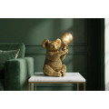 Designov&aacute; glamour stoln&iacute; lampa Tierra Glam ve zlat&eacute; barvě v podobě sed&iacute;c&iacute; koaly drž&iacute;c&iacute; kulat&eacute; skleněn&eacute; st&iacute;n&iacute;tko 34 cm