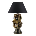 Moderní stolní lampa Pop Aterier s černým kuželovitým stínítkem z textilu a designovou nohou v patinovaném bronzovém provedení s podobě busty buldoka s doutníkem a slunečními brýlemi v motorkářské bundě a čepici v pop art stylu