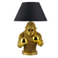 Moderní stolní lampa Pop Atelier s černým kulatým stínítkem z textilu s rozšířenou spodní částí a podstavou v podobě sochy polfigury opice v pop art stylu s boxerskými rukavicemi ve zlatém provedení
