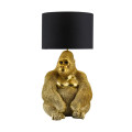 Art deco stolní lampa Tierra Glam s podstavou se sochou sedící opice v lesklém zlatém provedení s detaily srsti a obličeje s černým textilním stínítkem válcovitého tvaru