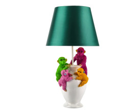 Modern&iacute; glamour stoln&iacute; lampa Tierra Glam se zelen&yacute;m leskl&yacute;m st&iacute;n&iacute;tkem s roz&scaron;&iacute;řenou spodn&iacute; č&aacute;st&iacute; s podstavou v b&iacute;l&eacute; barvě ve tvaru v&aacute;zy s dekorem v podobě čtyř opic v zelen&eacute; a růžov&eacute; a žlut&eacute; barvě se zlat&yacute;mi detaily
