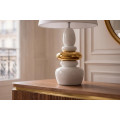 Modern&iacute; art deco b&iacute;l&aacute; stoln&iacute; lampa Caillou se zlat&yacute;m detailem s designem naskl&aacute;dan&yacute;ch kamenů a polohovateln&yacute;m st&iacute;n&iacute;tkem 68 cm