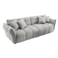 Moderní designová trojsedačka Yang s potahem z buklé látky s výraznou smyčkovitou strukturou ve světle šedé barvě s lineárním prošíváním se čtvercovým vzorem ve stylu cloud se zešikmenými bočními opěrkami a čtyřmi polštáři a nízkými černými nožičkami