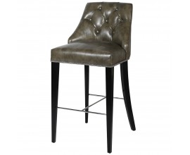 Chesterfield kožená zelenohnědá barová židle Selman s dřevěnými nohami a stříbrnými prvky 110cm