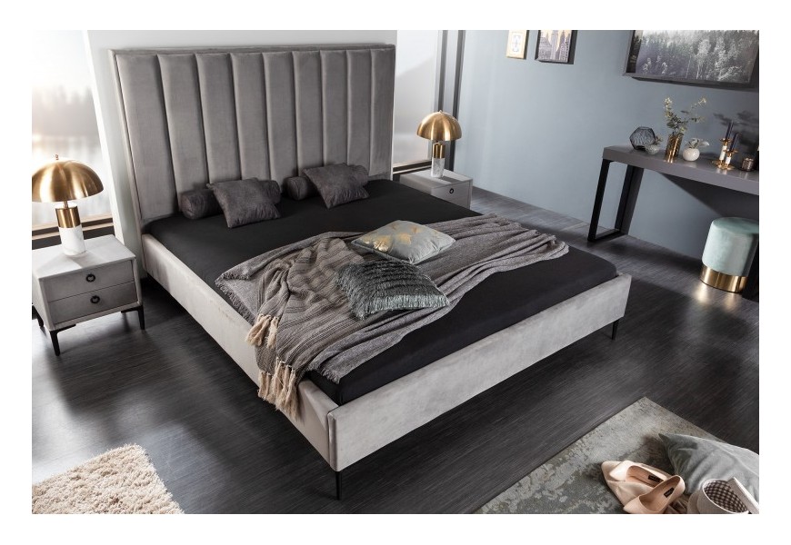 Stylová moderní manželská postel Everson s šedým potahem ze sametu, s vertikálními liniemi čalounění a s kovovými nožičkami