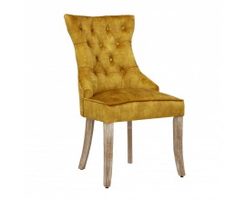 Designová chesterfield jídelní židle Torino hořčicově žluté barvy ze sametu s dřevěnými nohami a stříbrným klepadlem 96cm