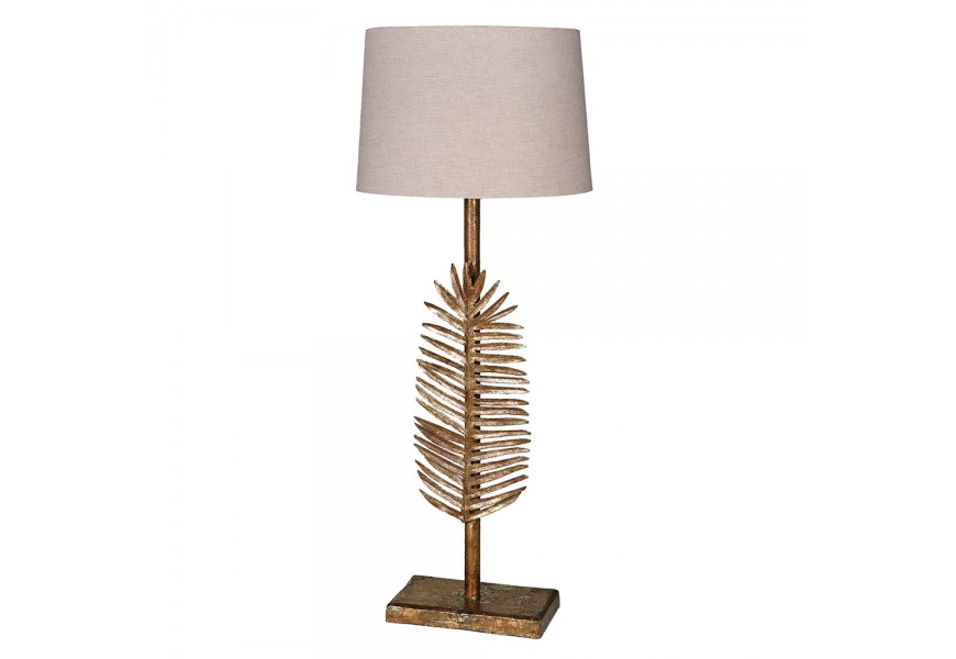 Art deco kovová zlatá stolní lampa Scoty s exotickou aplikací ve formě palmového listu na tyčové podstavě s kulatým stínítkem v béžové barvě