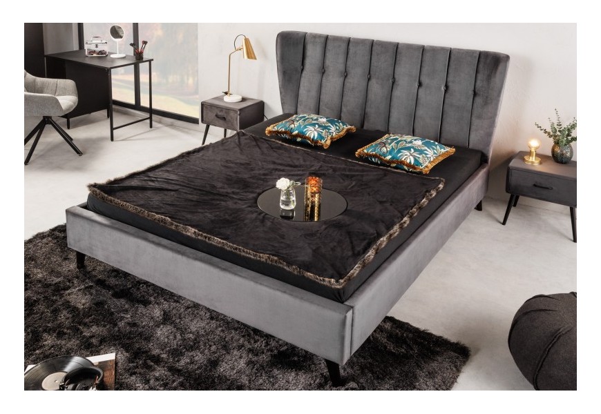 Moderní postel Alva s černými nožičkami ze dřeva a šedým sametovým čalouněním s nádechem retro stylu