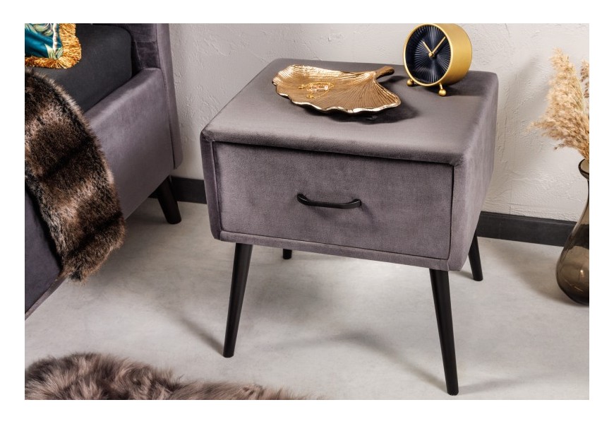 Designový noční stolek Alva s šedým čalouněním se sametu a šikmými kovovými nožičkami v černé barvě