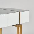 Art deco luxusní konzolový stolek Bynum bílý se skleněnou deskou a kovovými nožičkami ve zlaté barvě 120cm