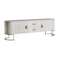 Exkluzivní glamour TV stolek Sedge bílé barvy se zásuvkami a dvířky se svislým reliéfním členěním a se zlatým kovovým nohama