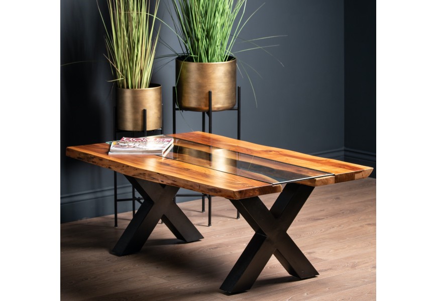 Stylový industriální konferenční stolek z kolekce Live Edge na kovových překřížených nožičkách s masivní akáciovou vrchní deskou v hnědé barvě se skleněným středem