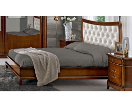 Klasická manželská postel Carpessio z masivního dřeva na oblých nožičkách s podlouhlým čelem a prošívaným čalouněním se šachovnicovým efektem