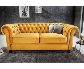 Designová chesterfield sedačka Milenna se sametovým potahem výrazné žluté barvy s černými nožičkami