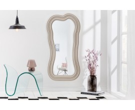 Asymetrické designové zrcadlo Swan s polyuretanovým rámem ve světle béžové barvě s kaskádovým efektem 100cm