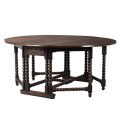 Dřevěný kulatý jídelní stůl Azrael tmavě hnědé barvy se sklápěcí deskou a praktickými zásuvkami