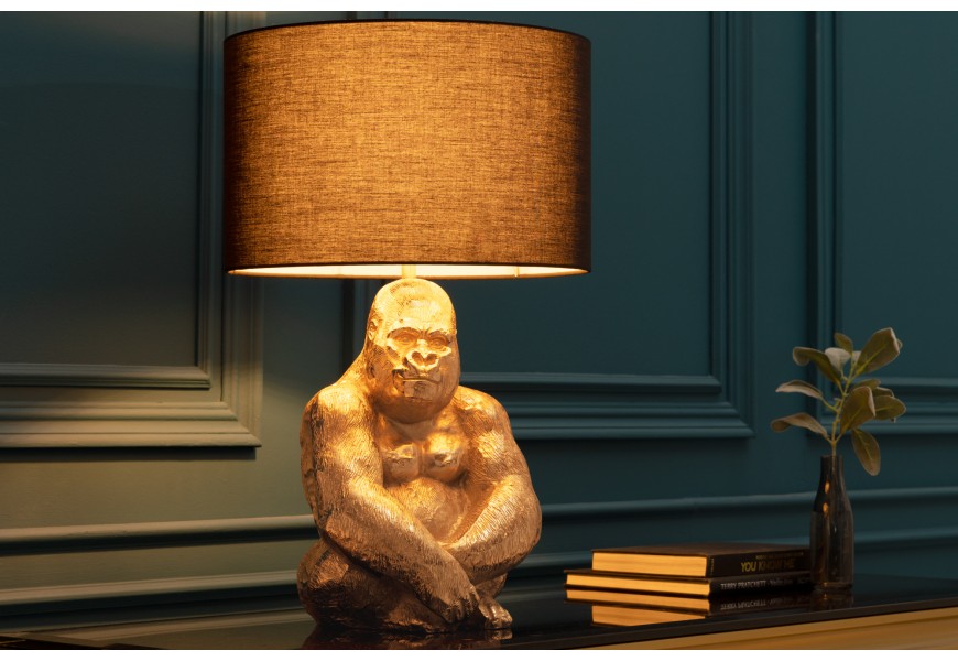 Art deco stolní lampa Apell s kovovou zlatou podstavou s designem sedící gorily as kulatým látkovým černým stínítkem