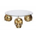 Designový konferenční stolek Hamlet s kulatou průhlednou skleněnou deskou a třemi nožičkami ve tvaru lebek z kovu ve zlaté barvě v glamour stylu