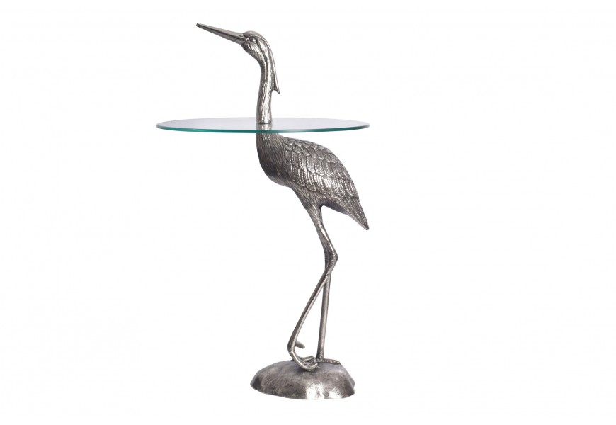 Designový příruční stolek Ardea s kulatou skleněnou deskou a se skulpturální kovovou podstavou ve tvaru stojící volavky ve stříbrné barvě
