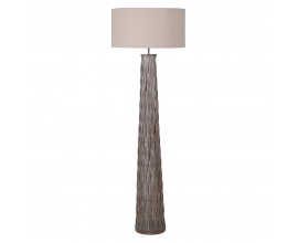 Designová etno stojací lampa Ranty s béžovým válcovým stínítkem z textilu s ratanovou šedou nohou