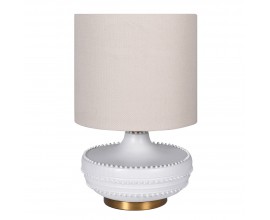 Designová art deco noční lampa Medina s keramickou podstavou v bílé barvě zdobenou korálkovým horizontálním reliéfem na zlatém kovovém podstavci s kulatým stínítkem ze lnu v naturální světlé béžové barvě