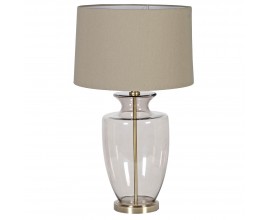 Skleněná stolní lampa Luminara v glamour stylu s kulatou starozlatou podstavou, kouřovou skleněnou nohou ve světle hnědém odstínu a lněným stínítkem v teplém béžovém odstínu