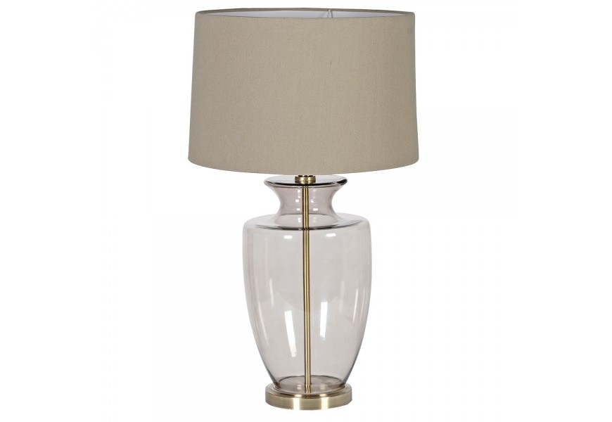 Skleněná stolní lampa Luminara v glamour stylu s kulatou starozlatou podstavou, kouřovou skleněnou nohou ve světle hnědém odstínu a lněným stínítkem v teplém béžovém odstínu