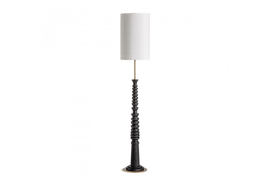 Luxusní etno stojací lampa Mulinos se stínítkem z bavlny ve válcovém tvaru s bouclé potahem v bílé barvě s vyřezávanou nohou v černé barvě s tyčí z kovu ve zlaté barvě