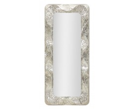 Glamour designové nástěnné zrcadlo Elissia v hranatém tvaru s lesklým stříbrným rámem z kovu a plastickým vlnitým dekorem po celém obvodu