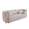 Art deco béžová třímístná sedačka Jina s potahem z bouclé látky s oblým asymetrickým opěradlem a geometrickými kulatými a válcovitými polštáři